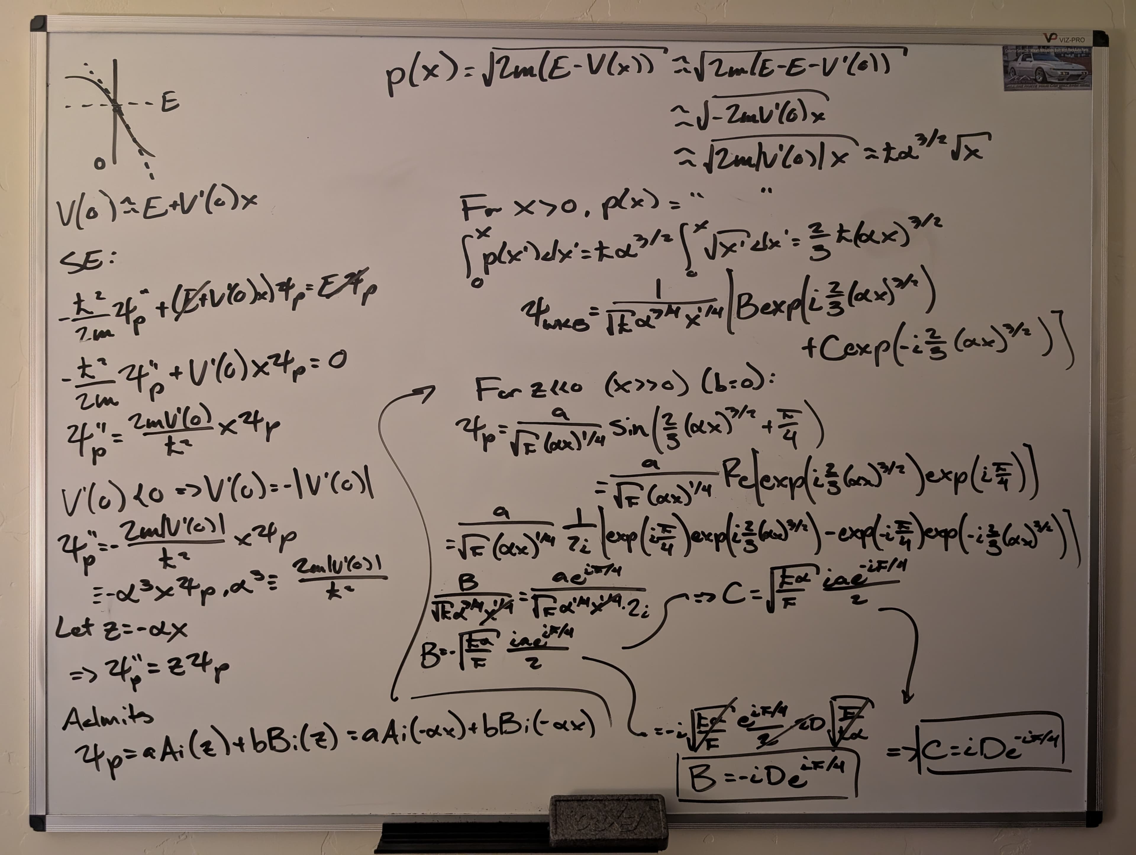A photo of a whiteboard filled with the solution to a quantum mechanics problem